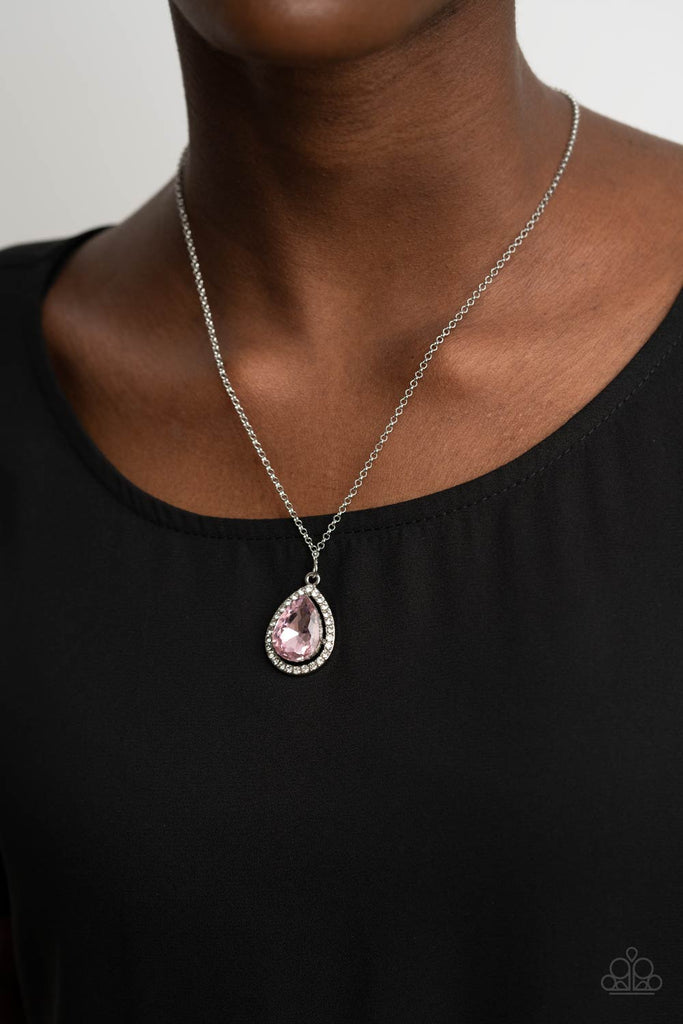 An oversized pink rhinestone teardrop is pressed into the center of a silver frame bordered in white rhinestones, creating a glamorous pendant below the collar. Features an adjustable clasp closure.  Sold as one individual necklace. Includes one pair of matching earrings.