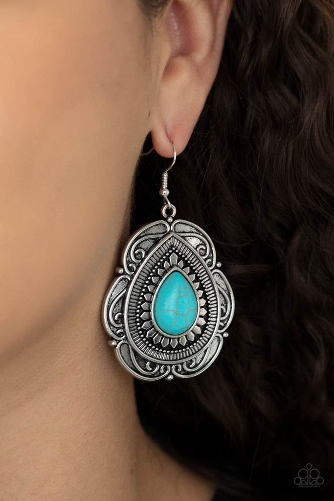 Dainty silver petals fan out from a refreshing teardrop turquoise stone center atop a backdrop of scalloped silver detail, creating a rustic frame. Earring attaches to a standard fishhook fitting.  Sold as one pair of earrings.