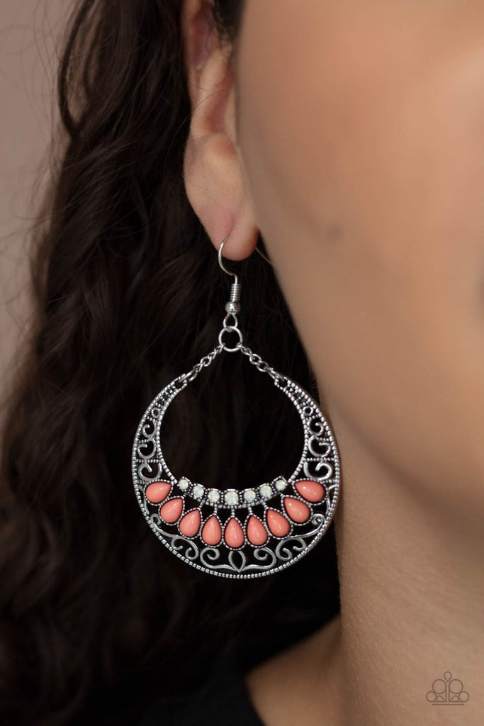Filled with a silver filigree backdrop, an antiqued crescent frame is adorned with dainty opalescent rhinestones and Burnt Coral teardrop beads for a mystical finish. Earring attaches to a standard fishhook fitting.  Sold as one pair of earrings.