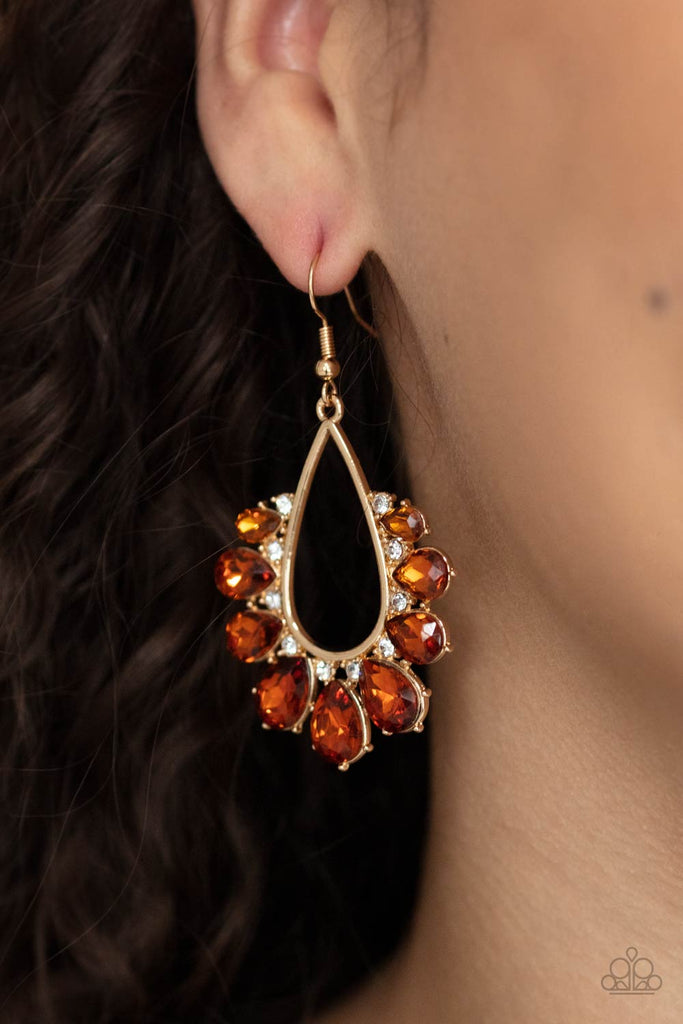Gradually increasing in size, a glittery collection of topaz teardrop rhinestones fan out from a white rhinestone dotted gold teardrop frame, creating a sparkly statement. Earring attaches to a standard fishhook fitting.  Sold as one pair of earrings.
