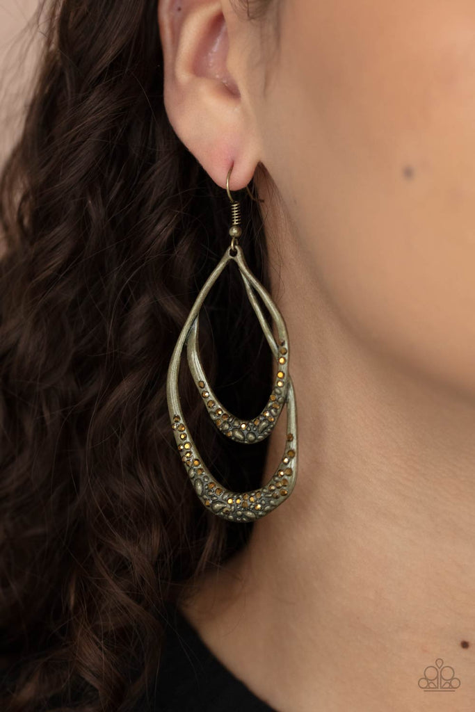 Dainty aurum rhinestones are encrusted along the bottom of warped brass teardrop frames that overlap into a glittery lure. Earring attaches to a standard fishhook fitting.  Sold as one pair of earrings.  New Kit