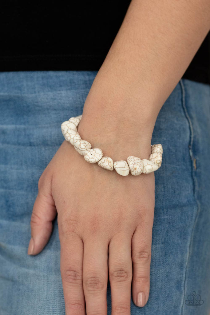 A collection of imperfect white stones are threaded along an invisible wire around the wrist, creating an earthy centerpiece. Features an adjustable clasp closure.  Sold as one individual bracelet.