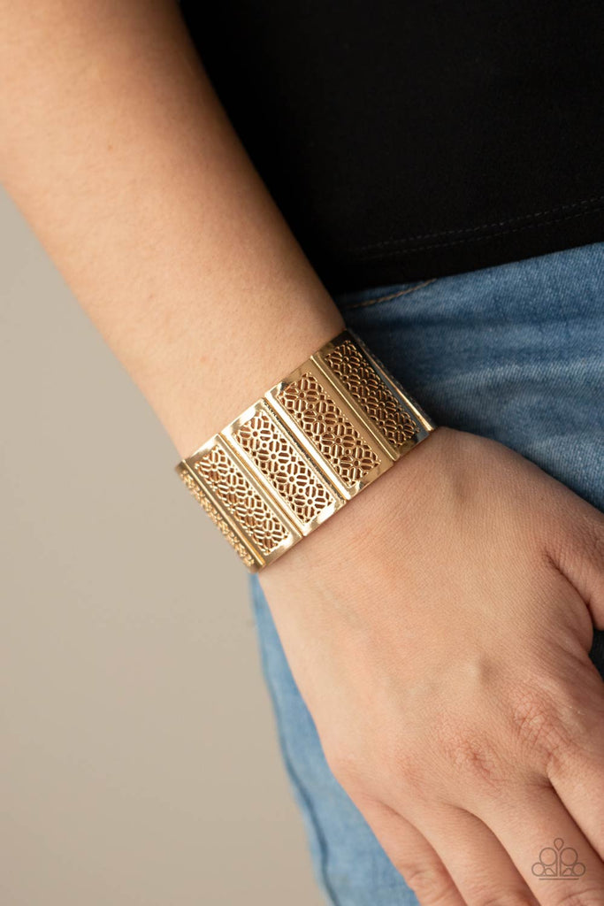 Filled with airy stenciled floral patterns, rectangular shiny gold frames are threaded along stretchy bands around the wrist, creating a whimsical centerpiece.  Sold as one individual bracelet.