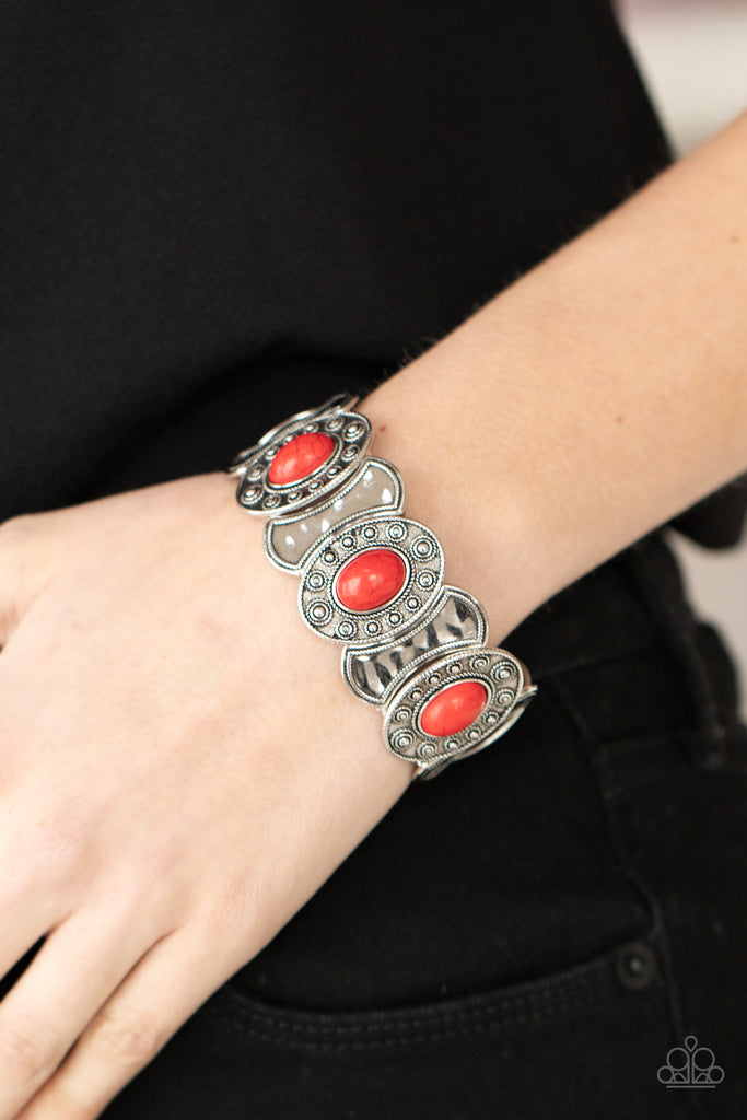 Dotted in ornate silver studs, red stone embellished silver frames join hammered silver plates along stretchy bands around the wrist for a colorful seasonal flair.  Sold as one individual bracelet.