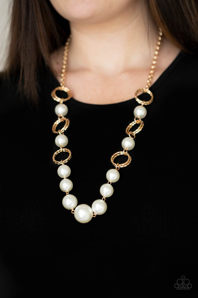 A dramatic collection of oversized white pearls and textured gold rings interconnect across the chest, creating a bold display of refinement. Features an adjustable clasp closure.  Sold as one individual necklace. Includes one pair of matching earrings.