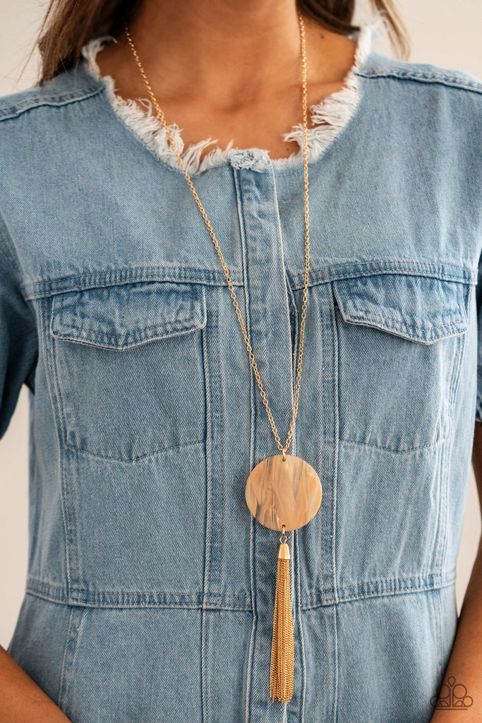 A dramatic gold chain tassel swings from the bottom of an oversized shell-like acrylic disc, creating a fabulously stacked pendant at the bottom of a lengthened gold chain. Features an adjustable clasp closure.  Sold as one individual necklace. Includes one pair of matching earrings.