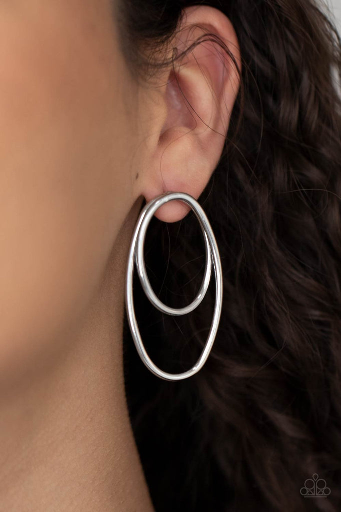 Shiny silver wires spin into a stacked oval frame, creating a dizzying look. Earring attaches to a standard post fitting.  Sold as one pair of post earrings.
