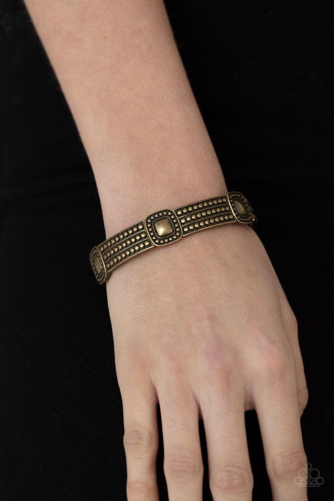 Featuring brass-studded patterns, square and rectangular frames are threaded along stretchy bands around the wrist for a rustic flair.  Sold as one individual bracelet.