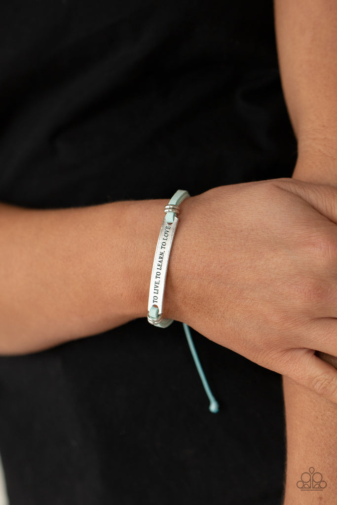 Infused with pairs of silver rings, a silver plate stamped in the phrase, "To Live, To Learn, To Love," is knotted in place around the wrist by blue suede bands for an inspirational look. Features an adjustable sliding knot closure.  Sold as one individual bracelet.
