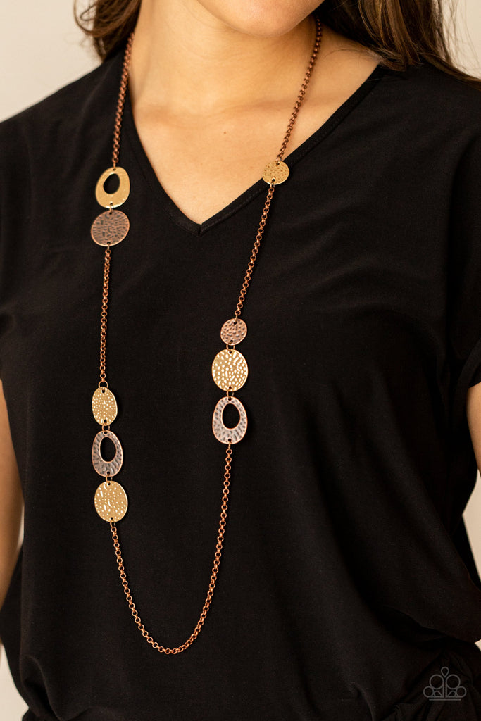 gallery-guru-copper A hammered collection of gold and copper discs and asymmetrical rings link with sections of rustic copper chain across the chest, creating a casual display. Features an adjustable clasp closure.  Sold as one individual necklace. Includes one pair of matching earrings.