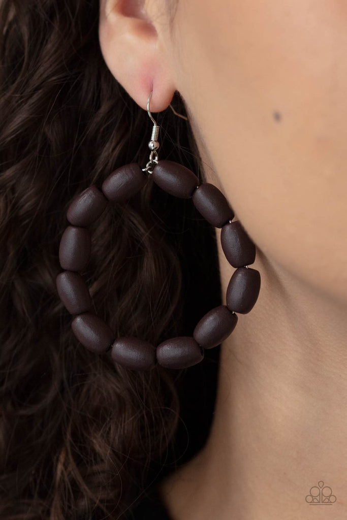 Chunky brown wooden beads are threaded along a dainty wire, creating an earthy hoop. Earring attaches to a standard fishhook fitting.  Sold as one pair of earrings.