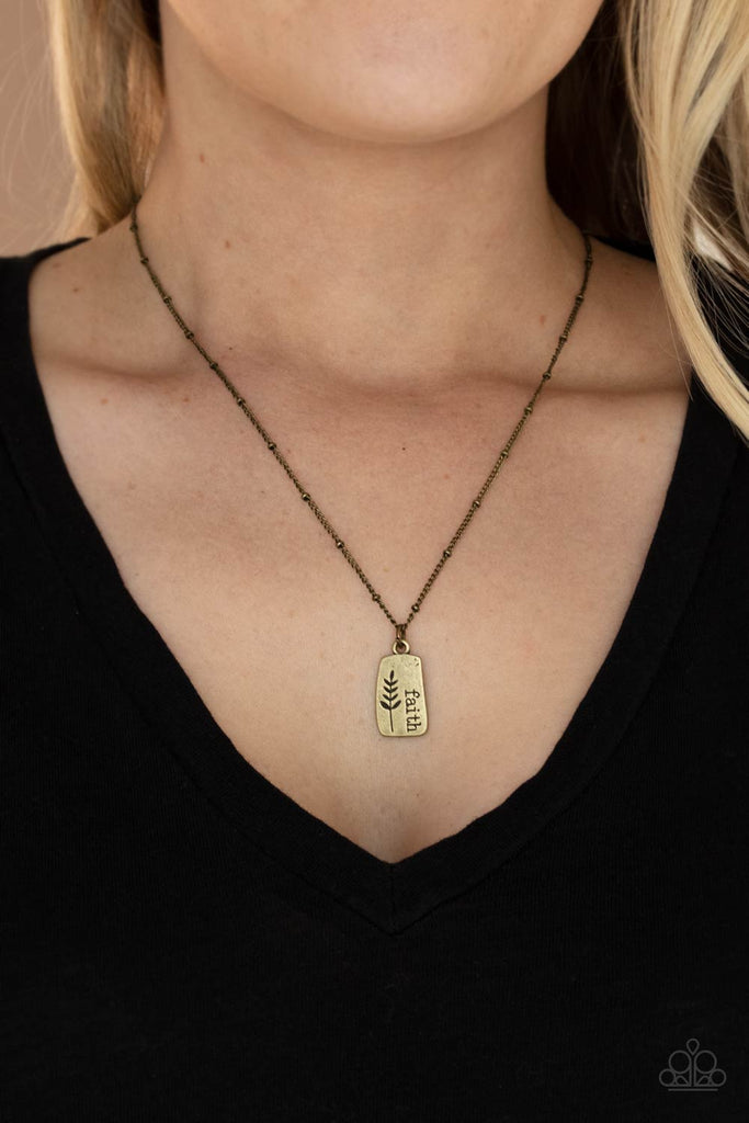 Stamped in a leafy accent, an asymmetrical brass plate is stamped in the word, "Faith," creating a dainty pendant below the collar. Features an adjustable clasp closure.  Sold as one individual necklace. Includes one pair of matching earrings.