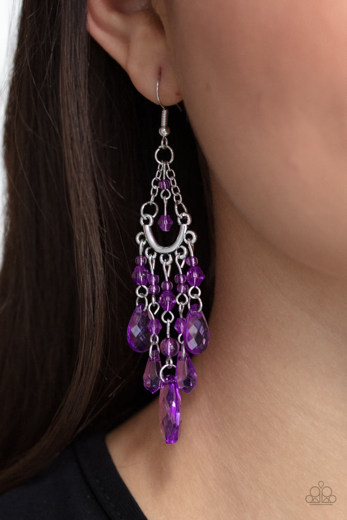 A glassy collection of purple teardrop, oval, and round crystal-like beads taper at the bottom of a silver half moon frame that is suspended by dainty silver chains. Matching beading swings from the top of the frame, creating a whimsical chandelier. Earring attaches to a standard fishhook fitting.  Sold as one pair of earrings.