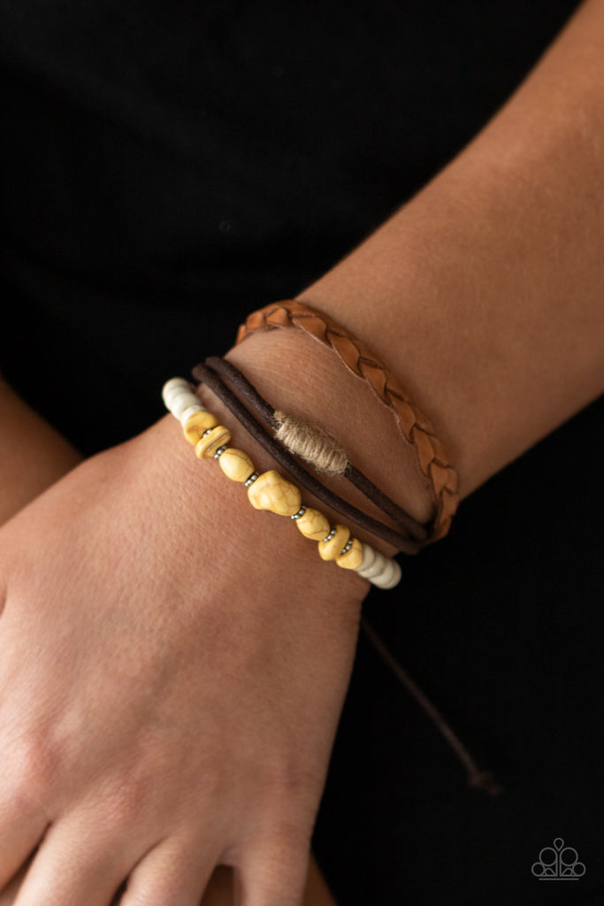 Mismatched strands of brown suede, braided brown leather, and yellow stones and white wooden beads layer across the wrist for a colorful seasonal look. Features an adjustable sliding knot closure.  Sold as one individual bracelet.