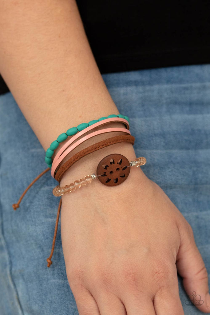 desert-gallery-blue Featuring a wooden floral centerpiece, mismatched strands of turquoise wooden beads, pink leather, brown suede, and topaz crystal-like beads layer across the wrist for a seasonal flair. Features an adjustable sliding knot closure.  Sold as one individual bracelet.