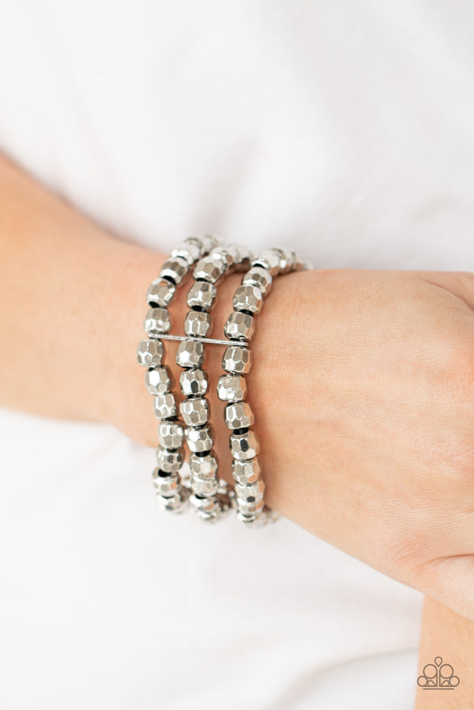 Held together with dainty silver fittings, rows of faceted silver beads are threaded along stretchy bands around the wrist, coalescing into bold layers.  Sold as one individual bracelet.