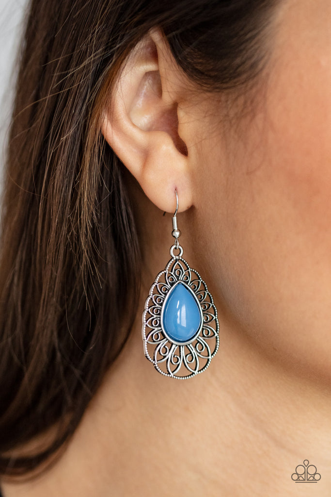 A shiny French Blue teardrop bead is pressed into the center of an airy silver teardrop frame radiating with ornate petals for a whimsical finesse. Earring attaches to a standard fishhook fitting.  Sold as one pair of earrings.