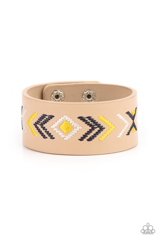 cliff-glyphs-yellow Yellow, blue, and white thread is stitched across the front of a brown leather band, creating a colorful tribal inspired pattern. Features an adjustable snap closure.  Sold as one individual bracelet.