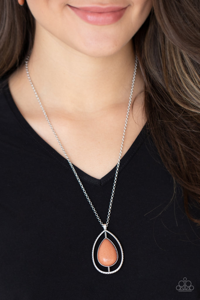 Attached to a textured silver like rod, an earthy brown stone teardrop is nestled inside an airy silver teardrop frame, creating an earthy pendant at the bottom of a shiny silver chain. Features an adjustable clasp closure.  Sold as one individual necklace. Includes one pair of matching earrings.