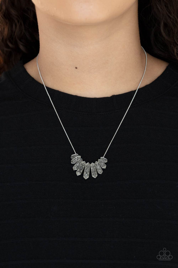 A row of silver obelisk-like monuments gradually decrease in size as they fan out across the collar. Delicately embossed with textured diamond shapes, they march along a dainty round silver chain. Features an adjustable clasp closure.  Sold as one individual necklace. Includes one pair of matching earrings.