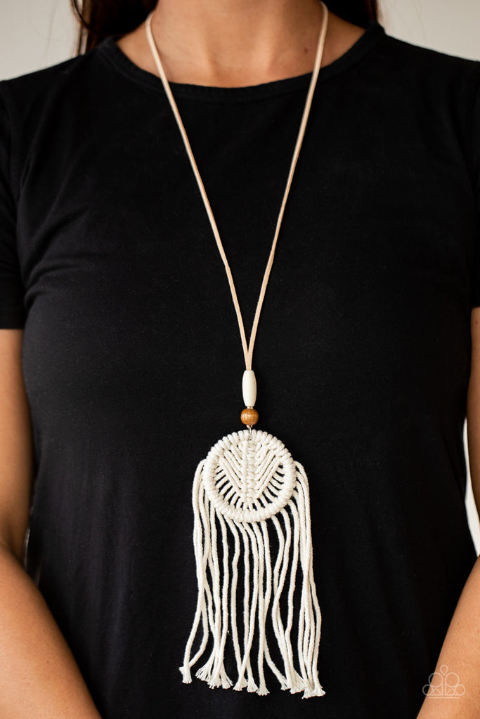 Infused with white and brown wooden beads, white twine-like cording knots into an ornate macramé dreamcatcher inspired pendant at the bottom of a lengthened piece of tan suede. Features an adjustable clasp closure.  Sold as one individual necklace. Includes one pair of matching earrings.