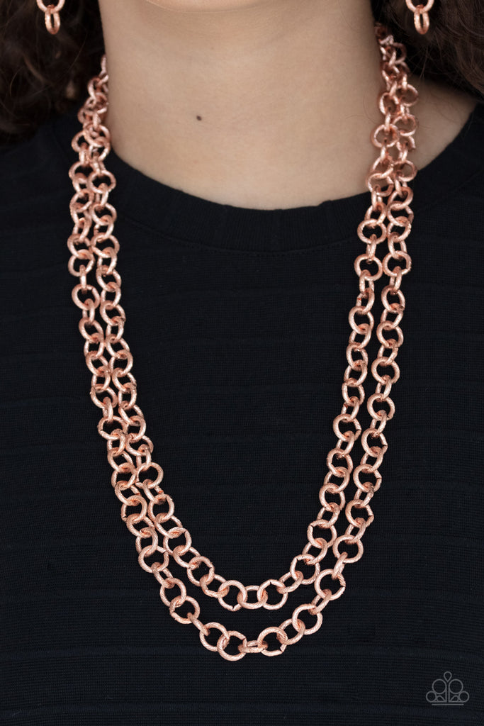 A seemingly infinite collection of textured shiny copper links connect into two dramatic rows across the chest, creating an intense industrial display. Features an adjustable clasp closure.  Sold as one individual necklace. Includes one pair of matching earrings.  