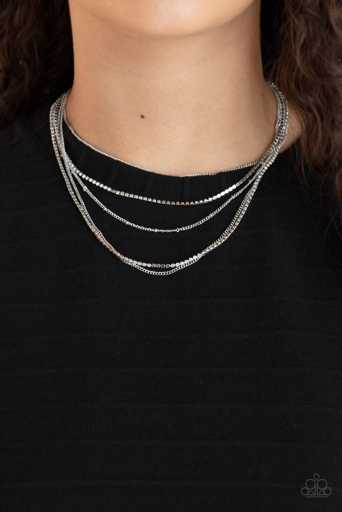 Dainty rows of classic silver chain, silver satellite chain, and strands of glassy white rhinestones, create dazzling layers around the neck. Features an adjustable clasp closure.  Sold as one individual necklace. Includes one pair of matching earrings.  