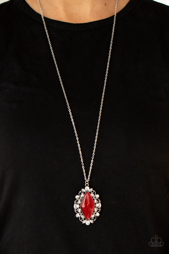 Dotted in glassy white rhinestones, leafy silver filigree blooms from an oversized red cat's eye stone, creating an enchanted pendant at the bottom of a lengthened silver chain. Features an adjustable clasp closure.  Sold as one individual necklace. Includes one pair of matching earrings.  