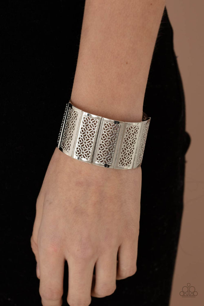 Filled with airy stenciled floral patterns, rectangular silver frames are threaded along stretchy bands around the wrist, creating a whimsical centerpiece.  Sold as one individual bracelet.