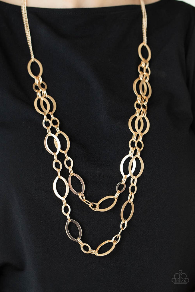 Stunning gold ellipses link together for two layers of bold, basic drama. The layers hang from a simple gold chain adding balance to the scene. Features an adjustable clasp closure.  Sold as one individual necklace. Includes one pair of matching earrings.