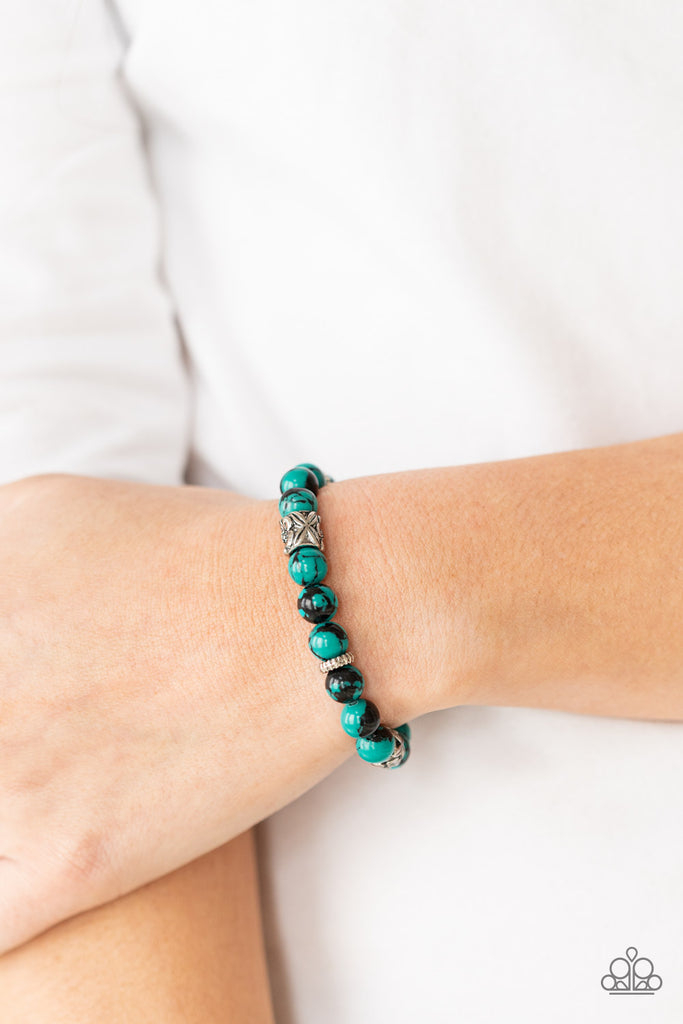 An earthy collection of glassy green and black beads, textured silver rings, and floral embossed beads are threaded along stretchy bands around the wrist, creating a seasonal centerpiece.  Sold as one individual bracelet.  