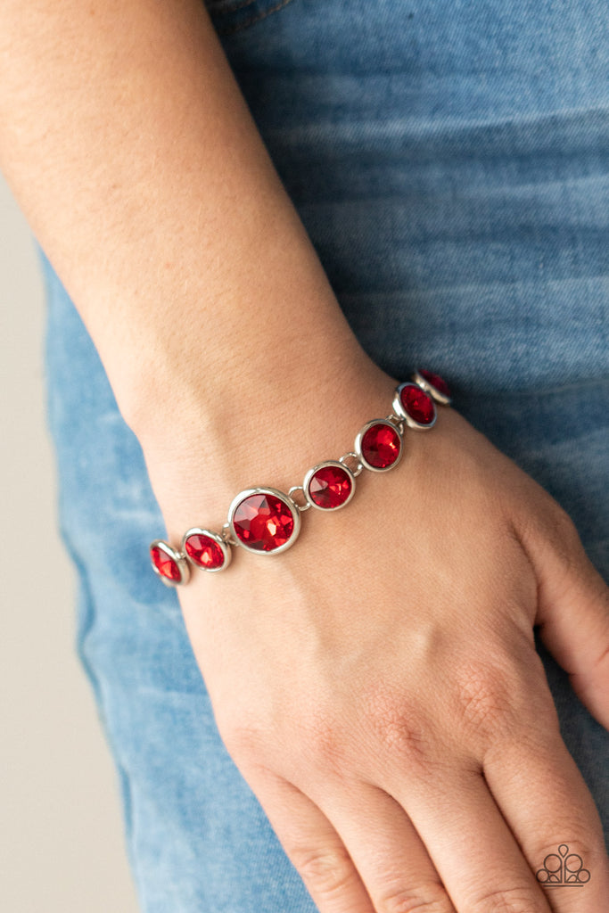 Featuring sleek silver fittings, an oversized collection of fiery red gems delicately link around the wrist. The centermost gem is slightly larger than the rest, adding a glamorous finish. Features an adjustable clasp closure.  Sold as one individual bracelet.  