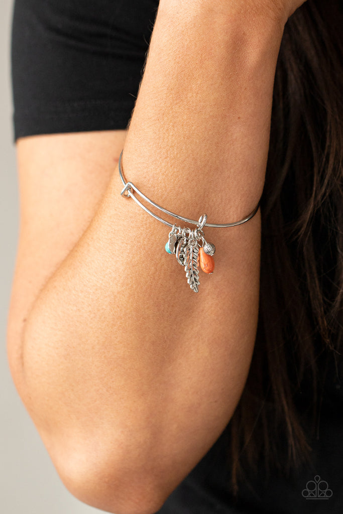 Featuring a shimmery silver feather charm, ornate silver beads and earthy stone beads glide along the fitted center of a dainty silver bangle for a whimsically charming look.  Sold as one individual bracelet.