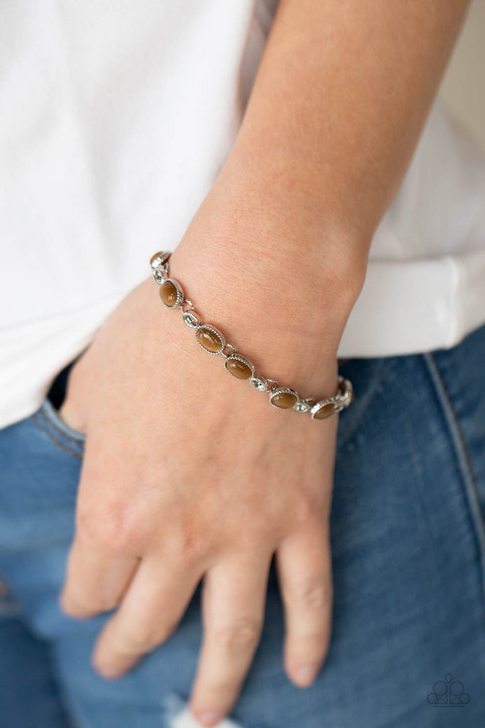 Featuring studded silver fittings, brown cat's eye stone frames delicately connect with ornate silver links around the wrist for an enchanted fashion. Features an adjustable clasp closure.  Sold as one individual bracelet.