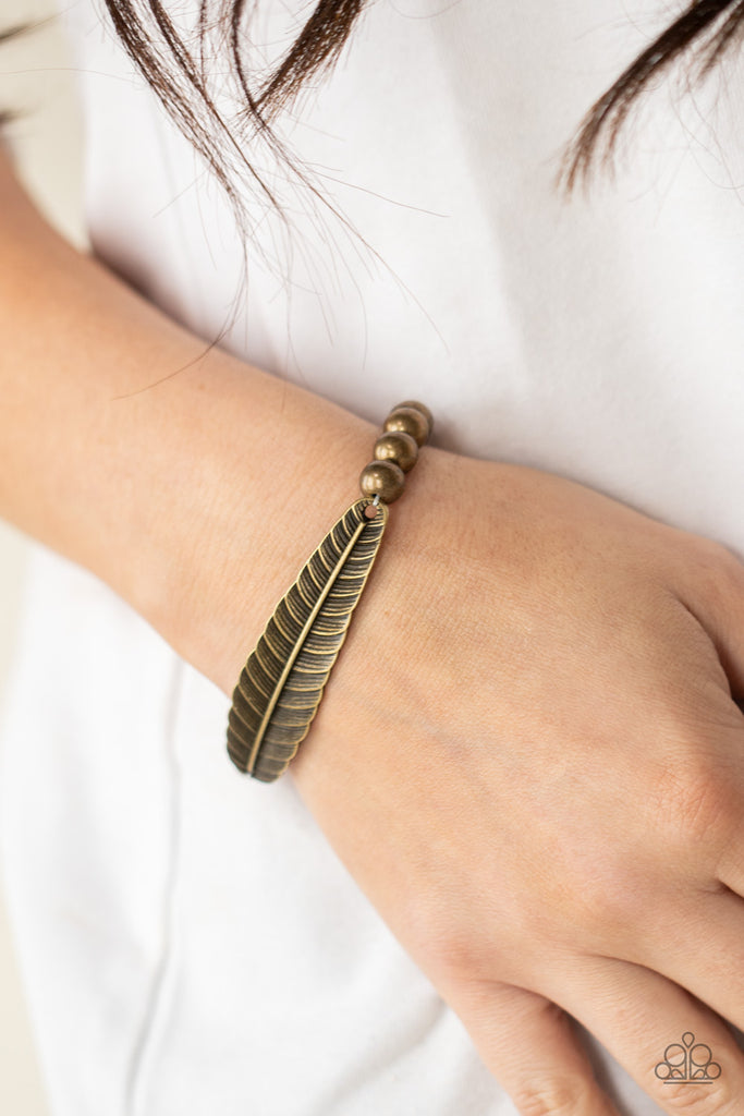 Infused with a lifelike brass feather frame, a row of rustic brass beads are threaded along stretchy bands around the wrist for a seasonal fashion.  Sold as one individual bracelet.  