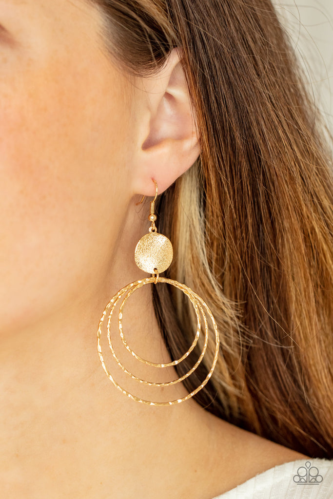 A shimmery wavy gold disc links atop a collection of three delicately hammered gold rings in concentric sizes for an out-of-this-world finish. Earring attaches to a standard fishhook fitting.  Sold as one pair of earrings.