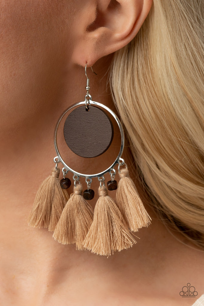 A wooden disc swings from the top of a shiny silver hoop that is adorned in dainty wooden cube beads and Desert Mist threaded tassels, creating an earthy fringe. Earring attaches to a standard fishhook fitting.  Sold as one pair of earrings.  