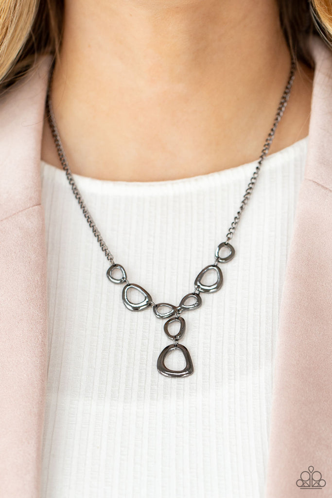 Irregular shaped gunmetal rings connect to a gunmetal chain as they make their way across the collar. Two rings dangle from the center for a stylish avant-garde fashion. Features an adjustable clasp closure.  Sold as one individual necklace. Includes one pair of matching earrings.