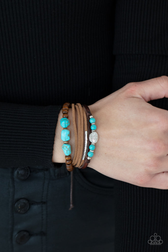 Featuring natural turquoise stones and silver accents, a collection of leather strands and wooden beads encircle the wrist in a subtle Southwestern fashion. Features an adjustable sliding knot closure.  Sold as one individual bracelet.