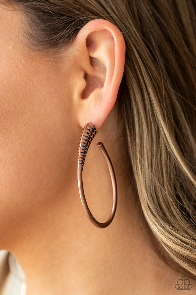A spiral of texture resembling a coil anchors an exaggerated oblong copper hoop that wraps around the ear. The high-sheen finish on the curved bar adds a hint of drama, as it refracts the light in a knockout finish. Earring attaches to a standard post fitting. Hoop measures approximately 1 1/2" in diameter.  Sold as one pair of hoop earrings.