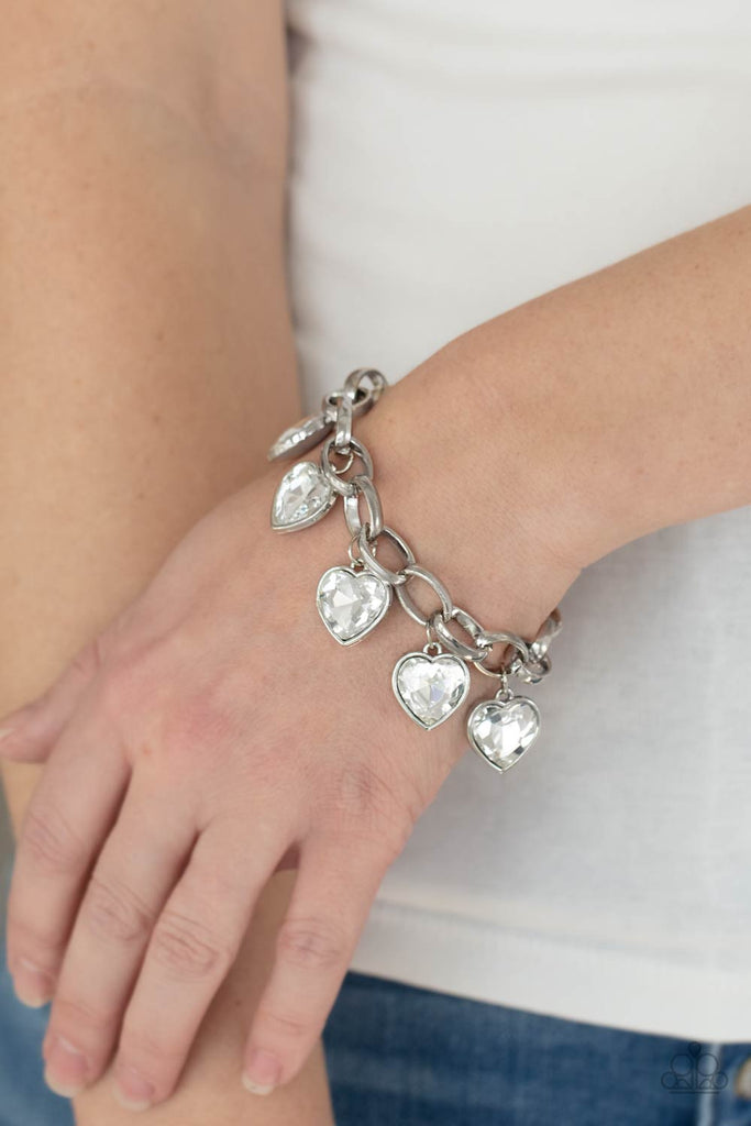White heart-shaped gems are encased in sleek silver frames that swing from an oversized silver chain, creating a sparkly fringe around the wrist. Features an adjustable clasp closure.  Sold as one individual bracelet.
