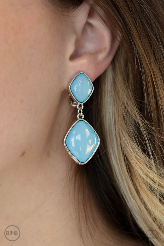 A pair of diamond shaped Cerulean opals are pressed into the centers of rustic silver frames that link into an ethereal lure. Earring attaches to a standard clip-on fitting.  Sold as one pair of clip-on earrings.  