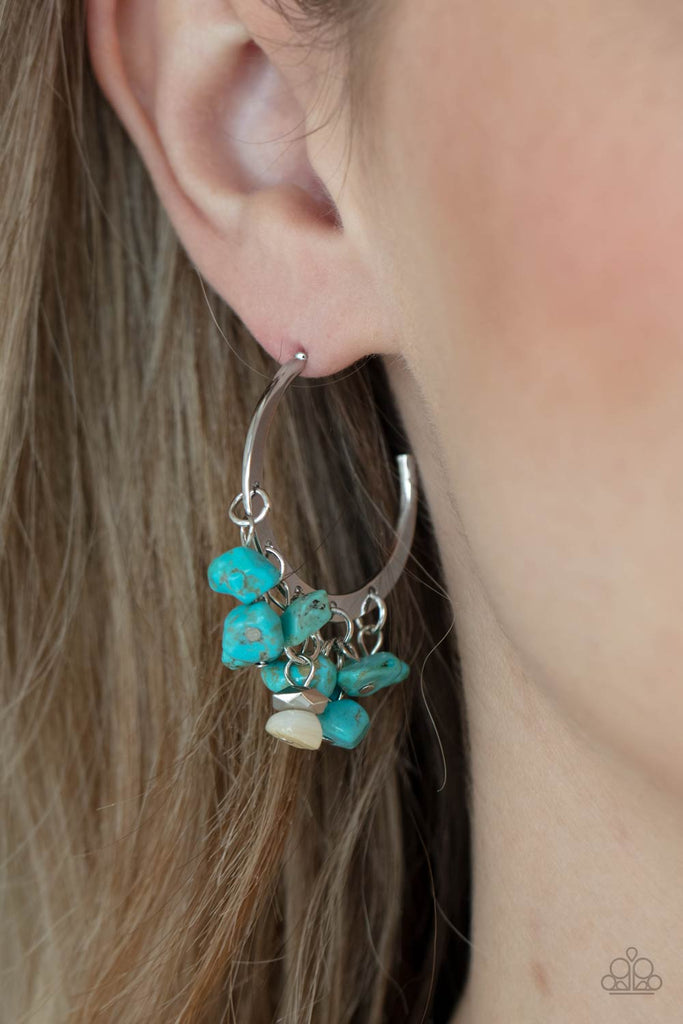 Clusters of turquoise pebbles swing from the bottom of a dainty silver hoop, creating an earthy fringe. A faceted silver and white stone bead swings from the center, adding an ethereal edge. Earring attaches to a standard post fitting. Hoop measures approximately 1 1/4" in diameter.  Sold as one pair of hoop earrings.
