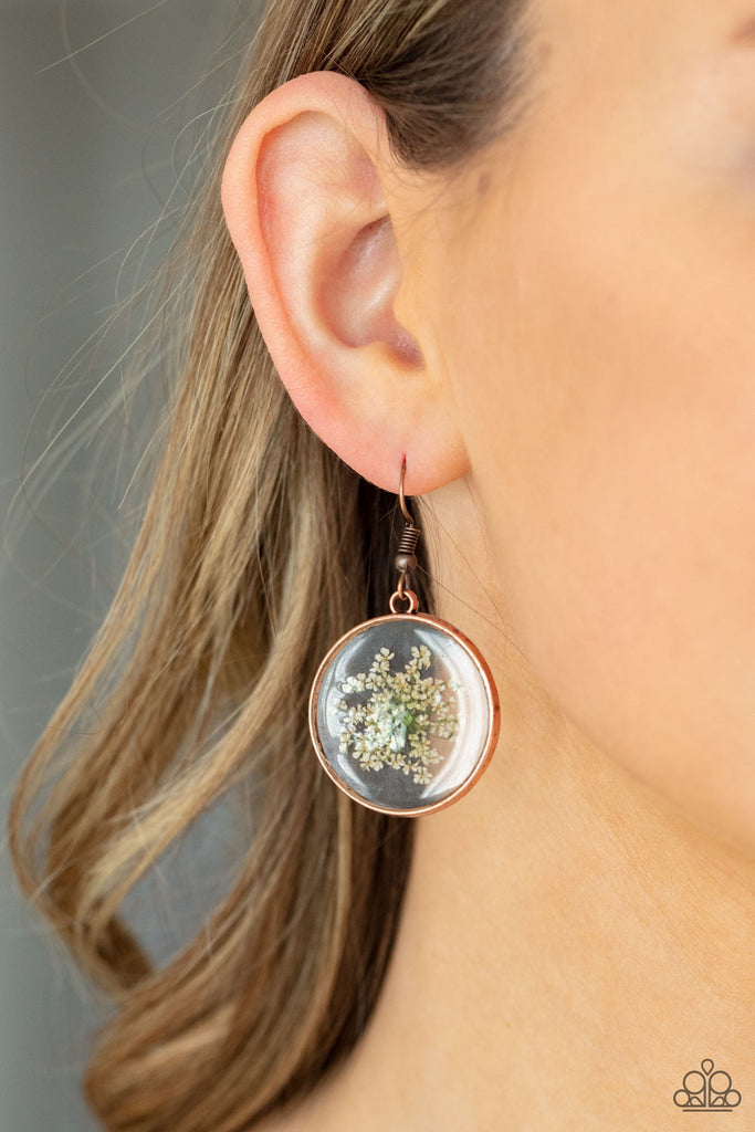 Dainty white firework flowers are encased inside a glassy casing bordered in an antiqued copper trim, creating a whimsical frame. Earring attaches to a standard fishhook fitting.  Sold as one pair of earrings.