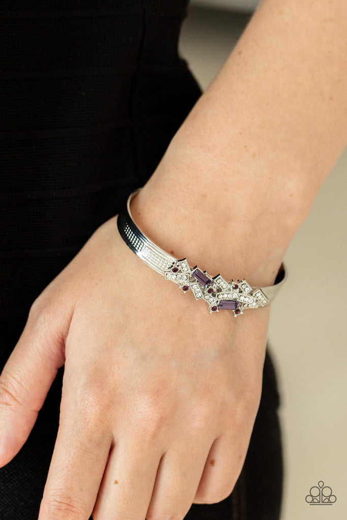 A jumble of dazzling purple and white rectangle-shaped rhinestones mingle with small purple sparkling rhinestones atop a modern stamped silver cuff.  Sold as one individual bracelet.