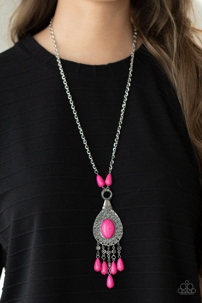 A hot pink oval stone sits center stage surrounded by swirly designs stamped into a wide silver frame. A fringe of silver floral beads culminating in hot pink stones swings like a pendulum at the end of a lengthened silver chain for a fashionable finish. Features an adjustable clasp closure.  Sold as one individual necklace. Includes one pair of matching earrings.