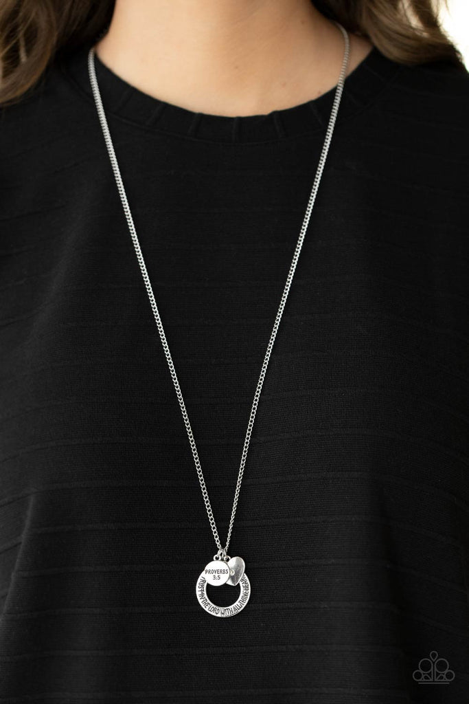 Dotted with a sparkly iridescent rhinestone, a dainty silver heart joins a silver ring stamped in the biblical passage, "Trust in the Lord with all thine heart," and a silver disc stamped in, "Proverbs 3:5," along the bottom of a lengthened silver chain, creating an inspirational pendant. Features an adjustable clasp closure.  Sold as one individual necklace. Includes one pair of matching earrings.