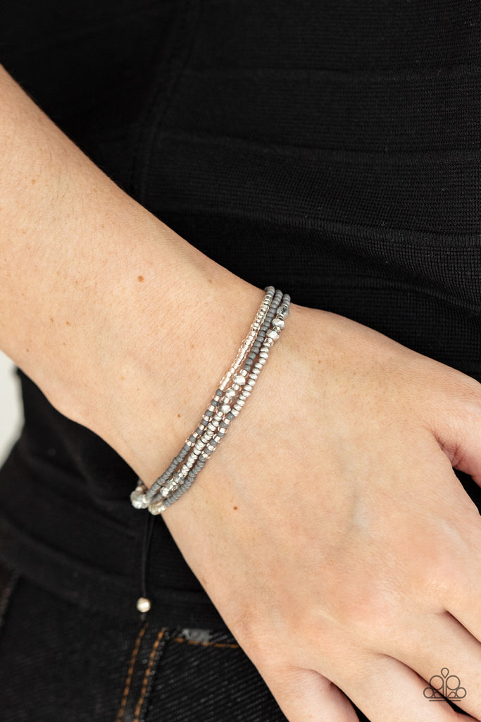 Three strands of silver and gray seed beads accented with iridescent multi-faceted beads give off a space-age vibe. Features an adjustable sliding knot closure.  Sold as one individual bracelet.  