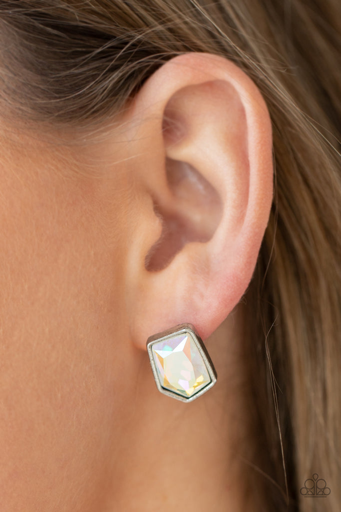 Featuring a raw asymmetrical cut, an iridescent gem is encased inside a sleek silver frame, creating a stellar display. Earring attaches to a standard post fitting.  Sold as one pair of post earrings.  