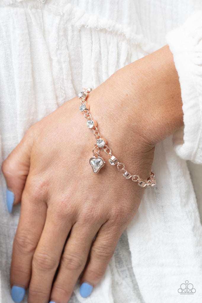 sweet-sixteen-rose-gold Brilliant white rhinestones in rose gold settings are linked together and accented with a charming white rhinestone heart that dangles sweetly from the wrist. Features an adjustable clasp closure.  Sold as one individual bracelet.